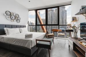 吉隆坡Scarletz KLCC Apartments by soulasia的一间卧室配有一张床、一张书桌和一个大窗户