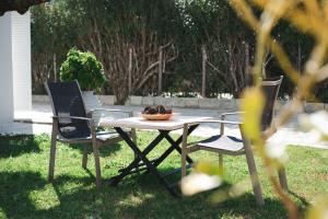 PandokrátorArmando Cottage的一张野餐桌,上面有两把椅子和一碗食物