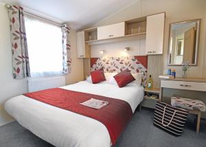 斯沃尼奇Swanage Coastal Park的一间卧室配有一张带红色毯子的大床