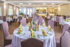 塔塔凯斯酒店的宴会厅配有白色桌子和紫色椅子