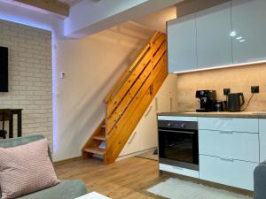 奥什恰德尼察BERUŠKA Apartmán的厨房配有白色橱柜和楼梯箱