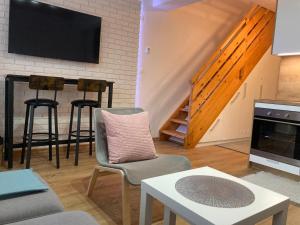 奥什恰德尼察BERUŠKA Apartmán的客厅配有椅子、电视和桌子