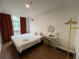马六甲旅乐酒店的一间卧室配有一张床、一张书桌和一个窗户。