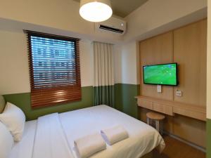 当格浪Hotel Osaka PIK2的配有一张床和一台平面电视的酒店客房