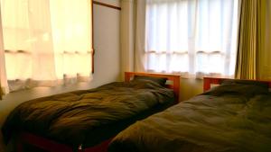 萩市women only ulala guesthouse - Vacation STAY 44819v的两张床位于带窗户的房间内