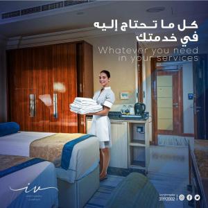 多哈Ivory Inn Hotel Doha Qatar的站在酒店房间,有床的男人
