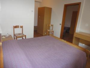 科马诺泰梅Hotel Bel Sit的一间卧室配有一张大床和两把椅子