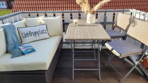 吕根岛上的维克Sonneninsel & Ankerplatz Wiek的阳台的沙发和桌子