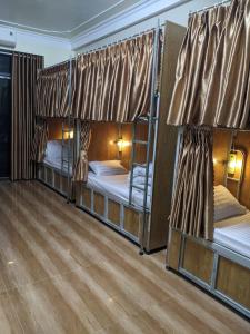 宁平Train Station Backpackers Hostel的铺有木地板的客房内配有三张双层床。