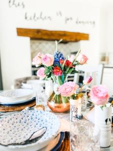 LlanuwchllynPen Y Bont Cottage的一张桌子上放着盘子和鲜花