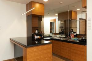 吉隆坡Dua Sentral by Cobnb的厨房配有木制橱柜和黑色台面