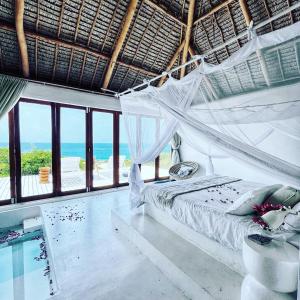 伊尼扬巴内Mar-Me-Quer, Eco Beach Retreat的一间带吊床的卧室,享有海景