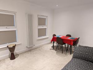 伦敦Fully-equipped flat in the city of London的一间用餐室,配有红色的桌子和椅子