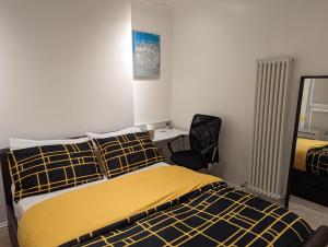 伦敦Fully-equipped flat in the city of London的一间卧室配有一张床、一张桌子和一把椅子