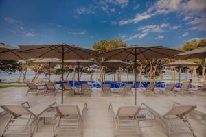 沃迪切Villa Arausa的海滩上的一组椅子和遮阳伞