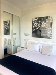 亚历山德拉岬角Ocean Views - Top floor的卧室配有白色的床和大镜子