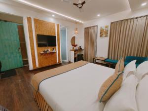德拉敦Ataraxia Crestmont Resort & Spa的酒店客房设有一张大床和一台电视。