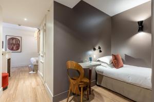 巴黎Le Nest by Sweet Inn的一间卧室配有一张床、一张桌子和一把椅子