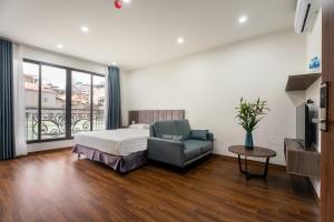 河内Granda Lake View Hotel & Apartment的一间卧室配有一张床、一张沙发和一台电视