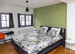 蒂尔堡Appartement La Charrette的卧室配有一张床、一张书桌和窗户。