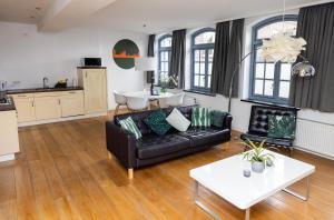 蒂尔堡Appartement La Charrette的客厅配有黑色沙发和桌子