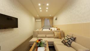 京都Stay SAKURA 京都 御苑东的带沙发和电视的客厅