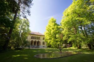 CouvetMaison Suchard, tradition & elegance in the Jura的一座树木繁茂的院子中建筑