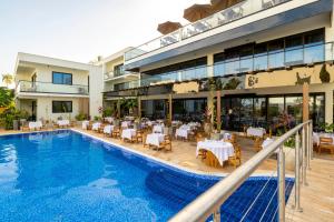 蓬圭TOA Hotel & Spa Zanzibar的一座设有游泳池和一间餐厅的酒店