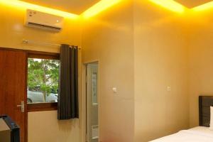 谏义里HP Residence Mitra RedDoorz near Alun Alun Kediri的天花板上设有黄色灯的卧室