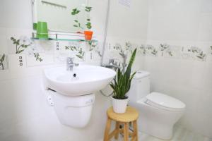 大叻Strawberry Hotel Dalat的白色的浴室设有水槽和卫生间。