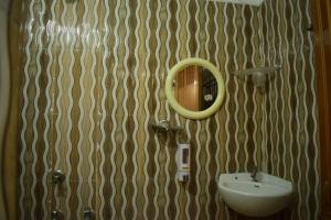 加雅Hotel Shakuntla Palace的浴室设有水槽和墙上的镜子