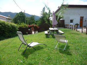 戴伊Le Tamaris的院子里有两把椅子、一张桌子和一把伞
