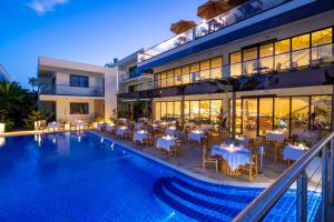 蓬圭TOA Hotel & Spa Zanzibar的酒店设有带桌椅的游泳池