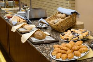 凯奇凯梅特Aranyhomok Business-City-Wellness Hotel的盘子上放有面包和糕点的柜台