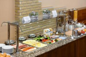 凯奇凯梅特Aranyhomok Business-City-Wellness Hotel的餐桌上的自助食物