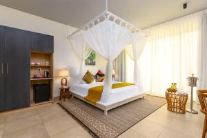 蓬圭TOA Hotel & Spa Zanzibar的一间卧室配有一张带天蓬的白色床