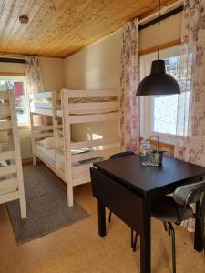 MåvikenMåvikens Camping的一间带两张双层床和一张桌子的用餐室