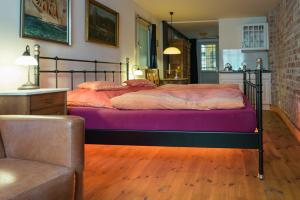 吕贝克哈泽酒店的一间卧室配有一张床、一张沙发和一把椅子
