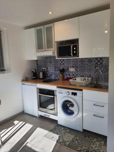 佩罗勒Appartement Pérols Centre的厨房配有洗衣机和微波炉。
