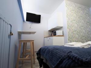 萨翁林纳Savonlinna Rentals的小房间设有一张床和墙上的电视