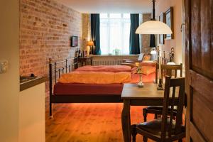 吕贝克哈泽酒店的一间卧室配有两张床、一张桌子和一张桌子。