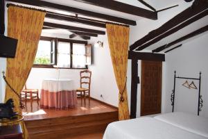SelayaHabitaciones Casona De Linares的一间卧室配有桌子、床和窗户