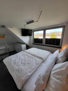 巴特诺因阿尔-阿尔韦勒Exklusive Wohnung mit Ahrblick 1 und Dachterrasse的一间卧室设有两张白色的床和窗户