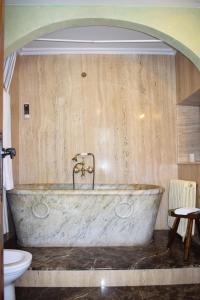 SelayaHabitaciones Casona De Linares的浴室配有大型石头浴缸及卫生间