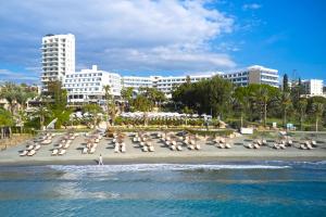利马索尔地中海海滩酒店 的海滩上有许多沙滩椅和建筑