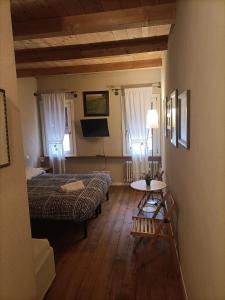 拉文纳R&B Il Cerchio的一间卧室配有两张床、一张桌子和一台电视。