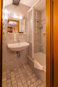 苏尔希尔施高登纳酒店的浴室配有水槽、淋浴和浴缸。