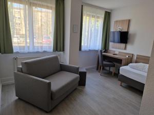 美因河畔法兰克福Hotel Ladage的酒店客房设有沙发、床和书桌