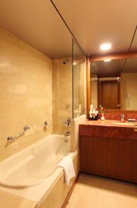 浦那极光塔酒店的带浴缸和盥洗盆的大浴室