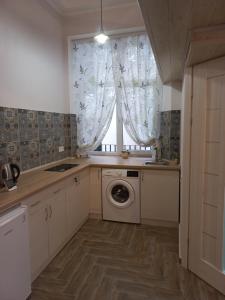 利沃夫Сьоме Небо的厨房配有洗衣机和窗户。